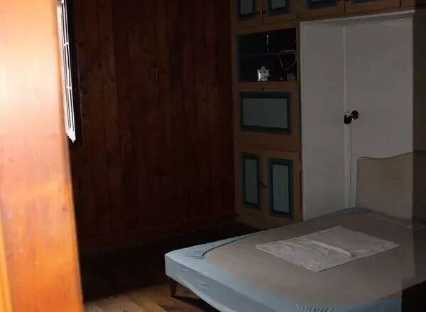 Discover this charming bedroom featuring a cozy bed and ample storage.