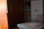 Discover this charming bedroom featuring a cozy bed and ample storage.