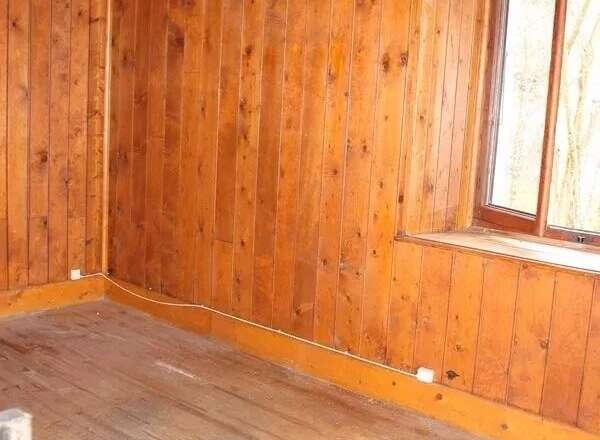 Discover the charm of this cozy room, featuring beautiful wooden walls and flooring that exude warmth and character.