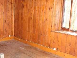 Discover the charm of this cozy room, featuring beautiful wooden walls and flooring that exude warmth and character.