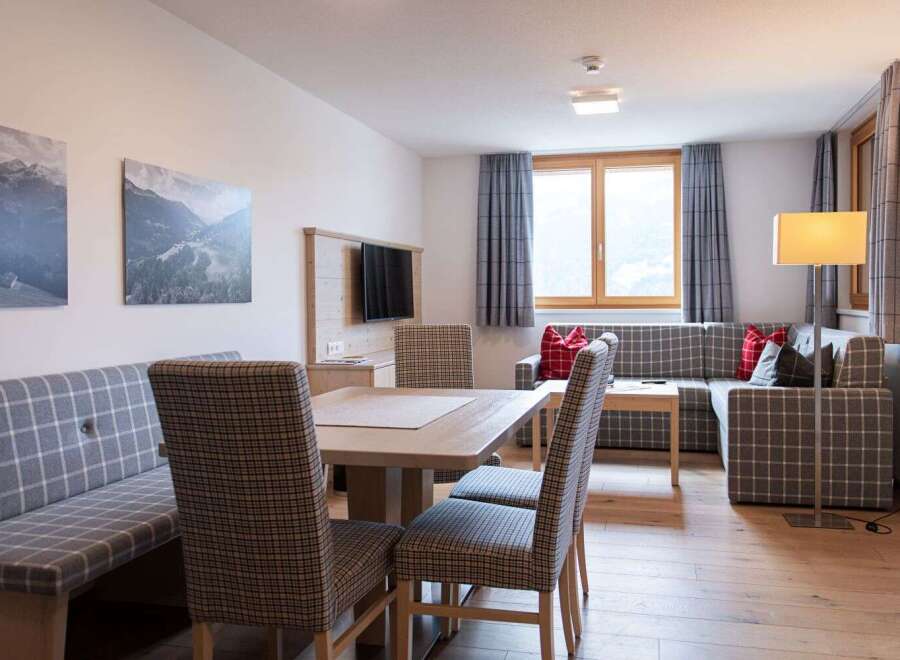 This cozy apartment boasts a spacious living area with a comfortable L-shaped sofa, perfect for relaxing after a day of adventure.