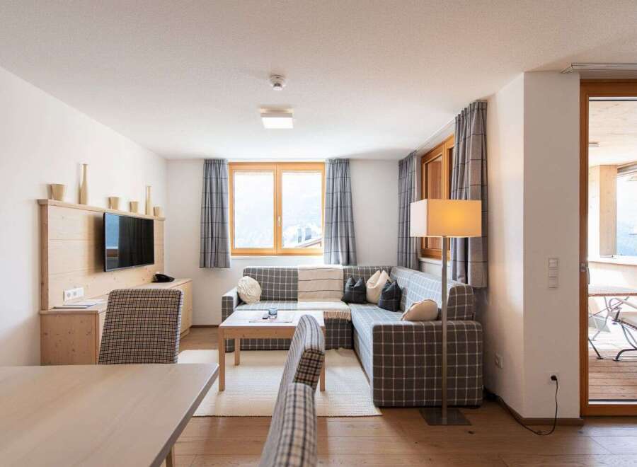 This cozy apartment boasts a spacious living area with a comfortable sectional sofa, perfect for relaxing after a day of exploring.