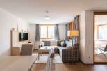 This cozy apartment boasts a spacious living area with a comfortable sectional sofa, perfect for relaxing after a day of exploring.