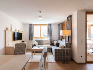 This cozy apartment boasts a spacious living area with a comfortable sectional sofa, perfect for relaxing after a day of exploring.