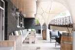 Relax on the outdoor patio, featuring comfortable seating and stylish wooden accents.