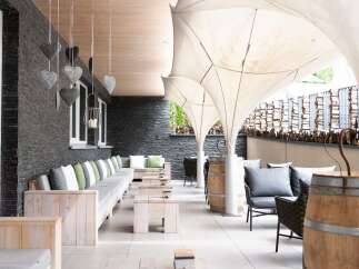 Relax on the outdoor patio, featuring comfortable seating and stylish wooden accents.