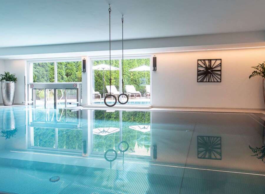 Indulge in a luxurious indoor pool experience, complete with hanging gymnastic rings for added fitness fun.