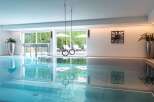 Indulge in a luxurious indoor pool experience, complete with hanging gymnastic rings for added fitness fun.