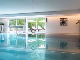 Indulge in a luxurious indoor pool experience, complete with hanging gymnastic rings for added fitness fun.