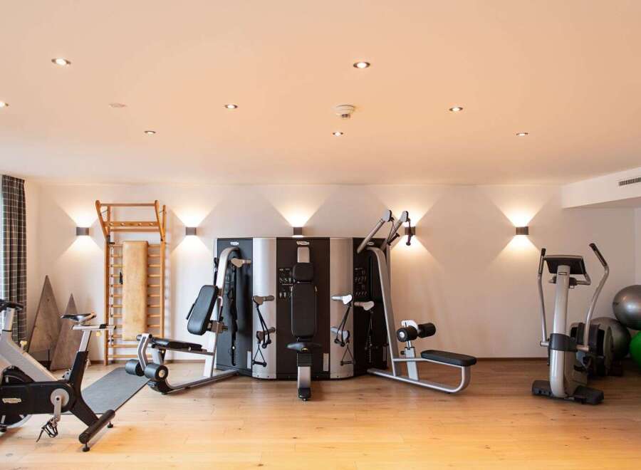 This well-equipped gym boasts a range of modern exercise machines, including a multi-station weight machine, stationary bikes, and a cross-trainer, perfect for a comprehensive workout.
