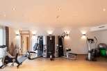 This well-equipped gym boasts a range of modern exercise machines, including a multi-station weight machine, stationary bikes, and a cross-trainer, perfect for a comprehensive workout.