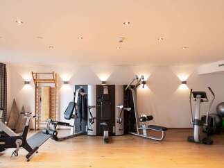 This well-equipped gym boasts a range of modern exercise machines, including a multi-station weight machine, stationary bikes, and a cross-trainer, perfect for a comprehensive workout.