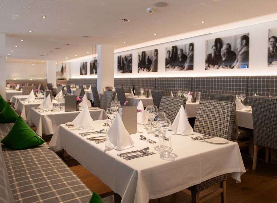 This elegant restaurant boasts a sophisticated ambiance with its plaid-patterned booths, crisp white tablecloths, and tasteful decor.