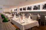 This elegant restaurant boasts a sophisticated ambiance with its plaid-patterned booths, crisp white tablecloths, and tasteful decor.