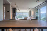 Modern mountain view home with open floor plan, featuring a large sectional sofa and dining table.