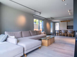 This stunning property boasts an open-plan living area with a spacious L-shaped sofa, perfect for relaxation and entertaining.