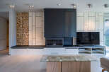 Stunning modern living room with a unique wood-stacked feature wall, sleek fireplace, and built-in entertainment center.
