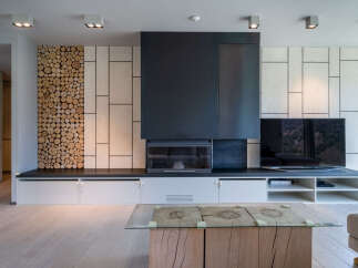 Stunning modern living room with a unique wood-stacked feature wall, sleek fireplace, and built-in entertainment center.