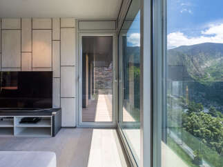 Modern living space with floor-to-ceiling windows offering breathtaking mountain views.