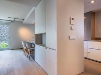 Modern apartment boasts sleek built-in cabinetry and light oak flooring.