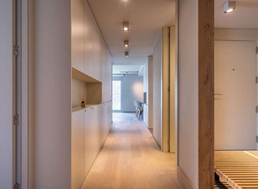 Light-filled hallway with built-in storage and wooden flooring.