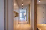 Light-filled hallway with built-in storage and wooden flooring.