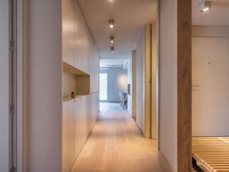 Light-filled hallway with built-in storage and wooden flooring.