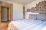 This stunning bedroom boasts a unique brick feature wall, adding character and texture to the space.