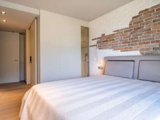 This stunning bedroom boasts a unique brick feature wall, adding character and texture to the space.