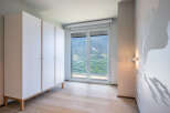 This stunning bedroom boasts a built-in wardrobe and large windows offering breathtaking mountain views.