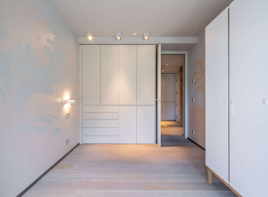 This stunning bedroom boasts built-in wardrobes and light oak flooring, creating a bright and airy atmosphere.