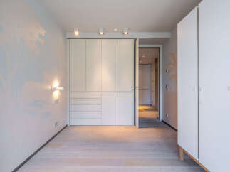 This stunning bedroom boasts built-in wardrobes and light oak flooring, creating a bright and airy atmosphere.