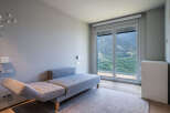 Modern mountain view room with comfortable daybed and large window.