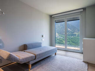 Modern mountain view room with comfortable daybed and large window.