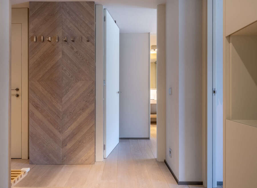 This stunning hallway boasts a herringbone wood feature wall, creating a warm and inviting atmosphere.