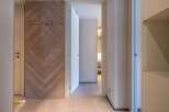 This stunning hallway boasts a herringbone wood feature wall, creating a warm and inviting atmosphere.