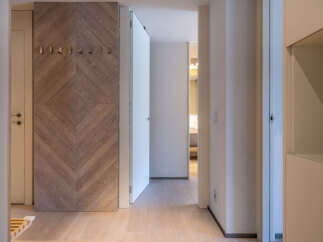 This stunning hallway boasts a herringbone wood feature wall, creating a warm and inviting atmosphere.