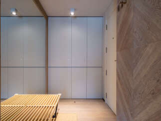 Modern hallway with built-in storage and wooden slatted bench.