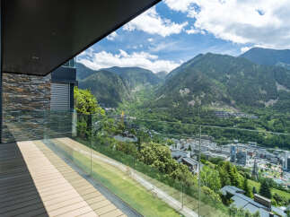 Luxury mountain view balcony with glass railings and composite decking.