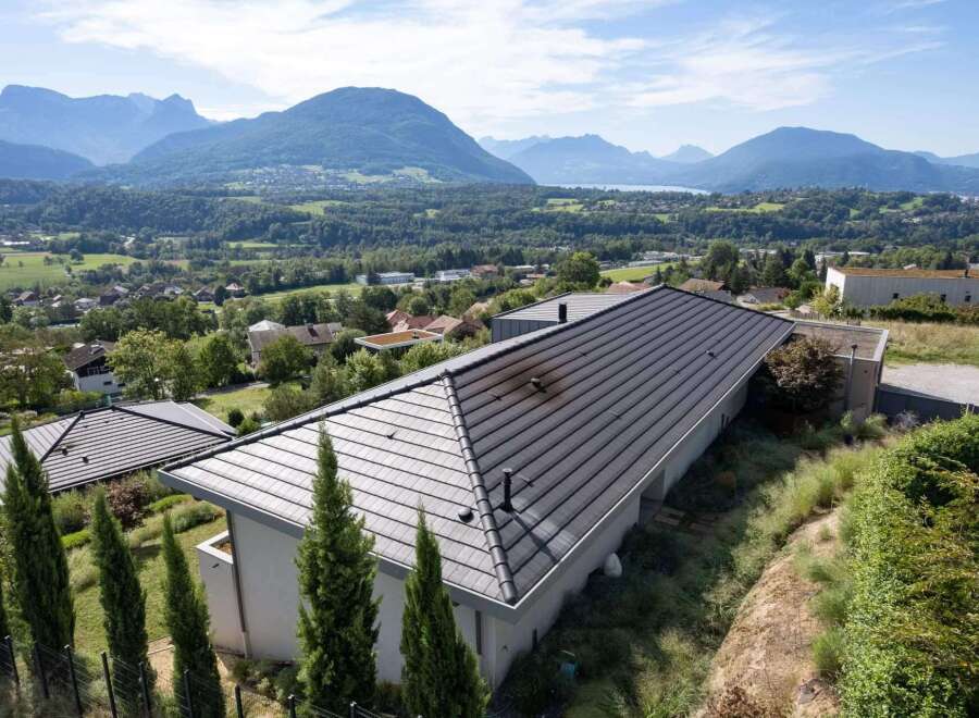This stunning property boasts a modern design with a sleek, dark gray roof that complements the surrounding mountain landscape.