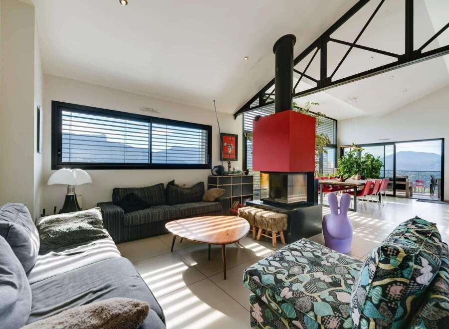 Stunning contemporary home boasts an open floor plan with floor-to-ceiling windows showcasing breathtaking mountain views.