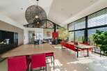 Stunning modern home boasts an open-concept kitchen and dining area with floor-to-ceiling windows offering breathtaking views.