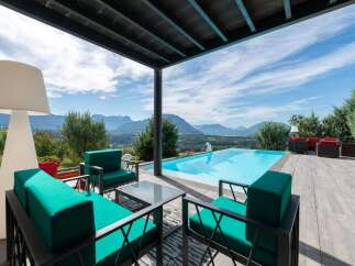 Luxury villa with infinity pool boasting breathtaking mountain views.