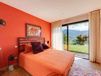 Wake up to breathtaking mountain views from this vibrant orange bedroom.