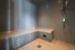 Indulge in this luxurious steam shower, featuring a built-in tiled seat for ultimate relaxation.