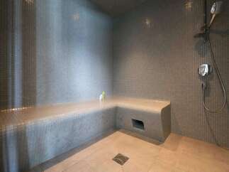 Indulge in this luxurious steam shower, featuring a built-in tiled seat for ultimate relaxation.