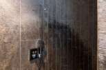 Indulge in this luxurious shower, featuring a rainfall shower head and sleek, modern fixtures.