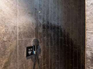 Indulge in this luxurious shower, featuring a rainfall shower head and sleek, modern fixtures.