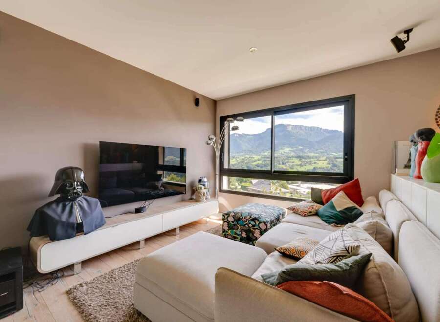 Luxury mountain view living room with modern sectional sofa and large screen TV.