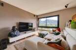 Luxury mountain view living room with modern sectional sofa and large screen TV.